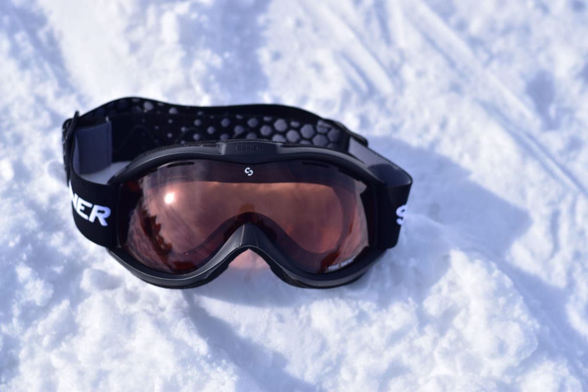 Snowboard goggles resting on fresh snow