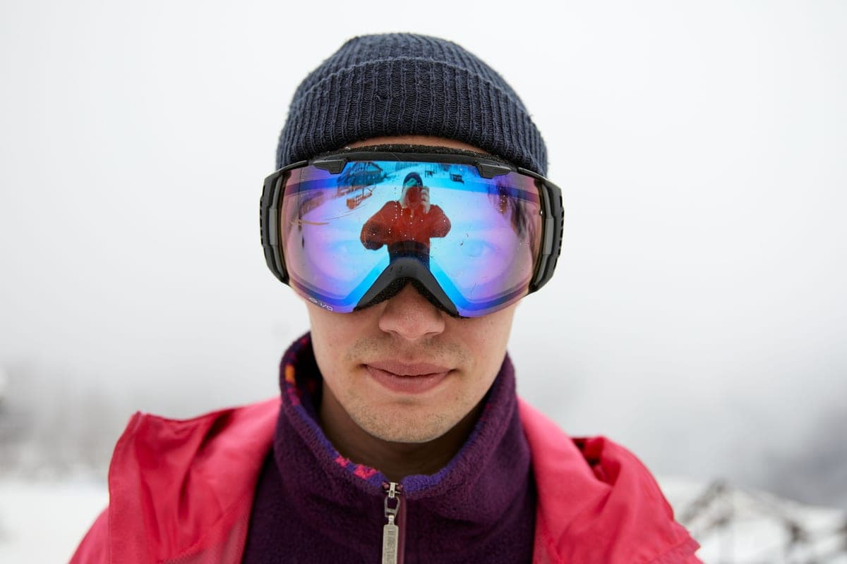 Close-up of a person in winter clothing wearing reflective snow goggles